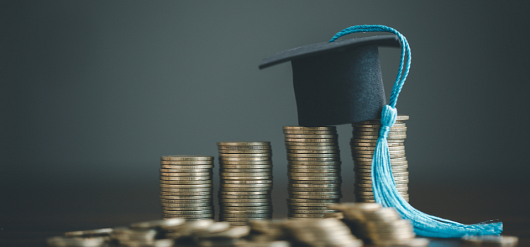 Graduate's mortar board sitting on a stack of coins